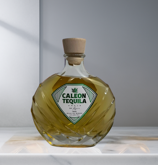 Caleon Tequila Añejo in a uniquely shaped glass bottle with wooden cork on white surface